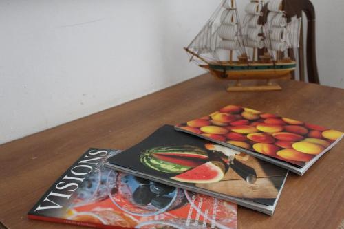 una mesa con un libro y un plato de fruta en Naftalan Guest House, en Baku