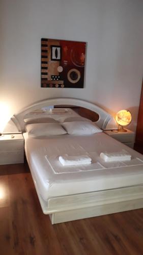ein weißes Bett in einem Schlafzimmer mit einer Lampe in der Unterkunft ★ Meniko's House ★ Amazing Sea View in Himarë