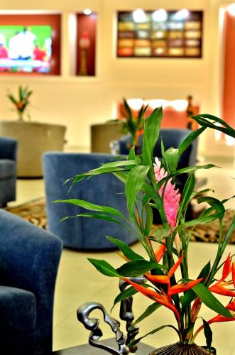 a table with a vase with flowers on it at The Cape Hotel in Monrovia