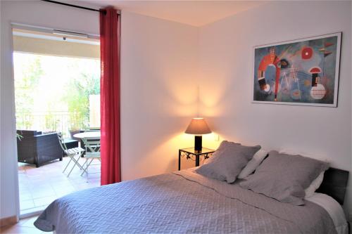 um quarto com uma cama e vista para uma varanda em Les Soleiades em La Londe-les-Maures