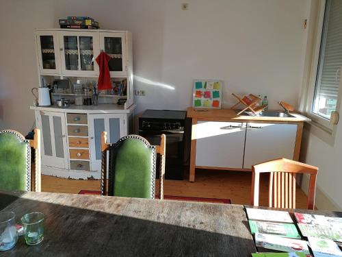 eine Küche mit einem Tisch, Stühlen und einer Theke in der Unterkunft Ferienwohnung Burg Lindenfels in Lindenfels