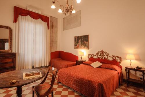 a hotel room with two beds and a table at Hotel Annalena in Florence