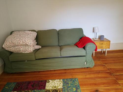 a green couch with two pillows on it in a living room at Ferienwohnung Burg Lindenfels in Lindenfels