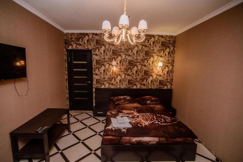 a bedroom with a bed and a chandelier at Хуторок in Smila