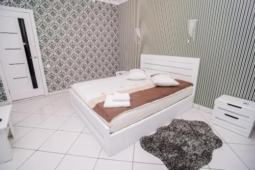 a white bedroom with a bed with towels on it at Хуторок in Smila