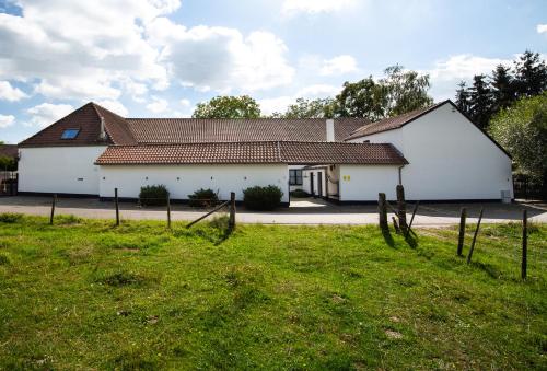 哈瑟爾特的住宿－Het Hemelsveld，前面有草地的白色房子