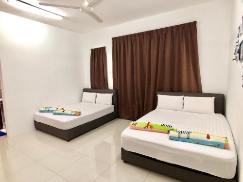 two beds in a room with two beds sidx sidx sidx sidx at Kampar Sakura 3 Landed in Kampar