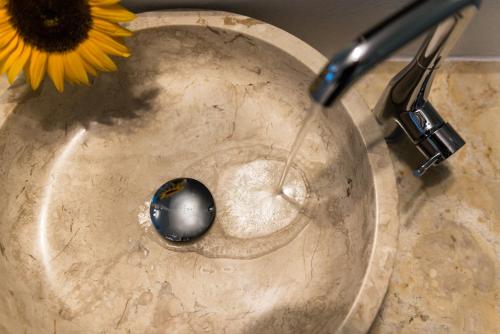 a sink with a spigot with water in it at Anteliz Suites in Fira