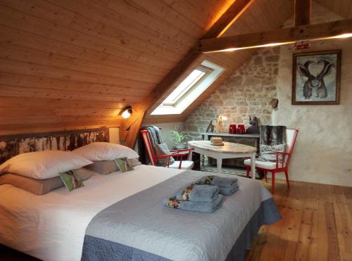 une chambre avec un grand lit dans un grenier dans l'établissement La grange aux lièvres, gîtes Kerdoel, à Cléder