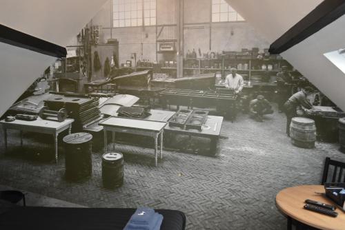 a black and white photo of a factory with people working at De Gusto in Schiedam