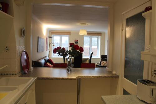 a kitchen with a vase of flowers on a counter at Cossack Holiday Home in Winchester