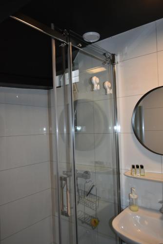 a shower with a glass door next to a sink at De Gusto in Schiedam