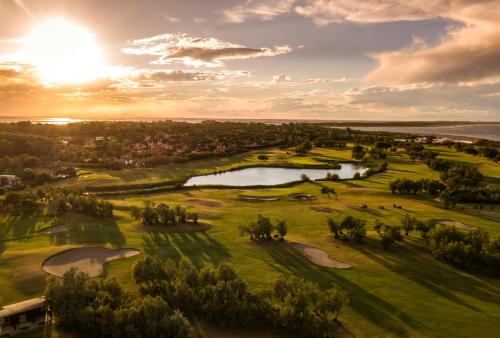 an aerial view of a golf course with a pond at Isola di Albarella Golf Hotel in Isola Albarella