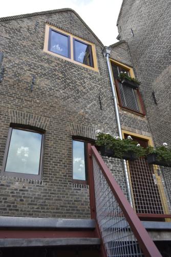 a brick building with windows and a staircase at De Gusto in Schiedam