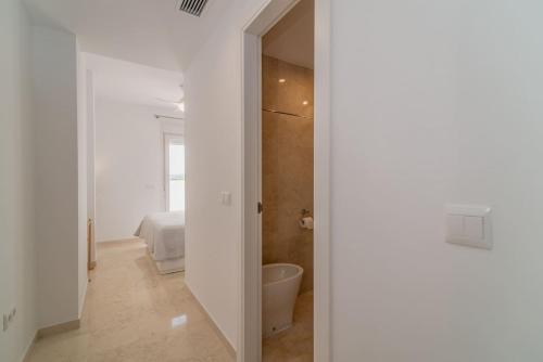 1 dormitorio y baño blanco con bañera. en Recently Decorated 2BDR Penthouse in Fuengirola, en Fuengirola