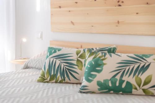 フエンヒロラにあるRecently Decorated 2BDR Penthouse in Fuengirolaのベッド1台(枕2つ、木製ヘッドボード付)