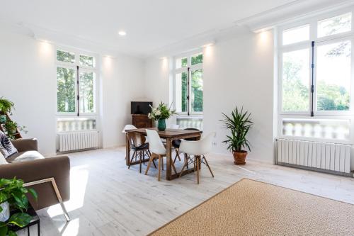 un salon avec une table, des chaises et des fenêtres dans l'établissement Château Côte de Nacre, à Ver-sur-Mer