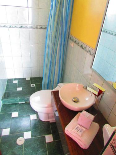 a bathroom with a toilet and a sink at Maya Inn in Puno