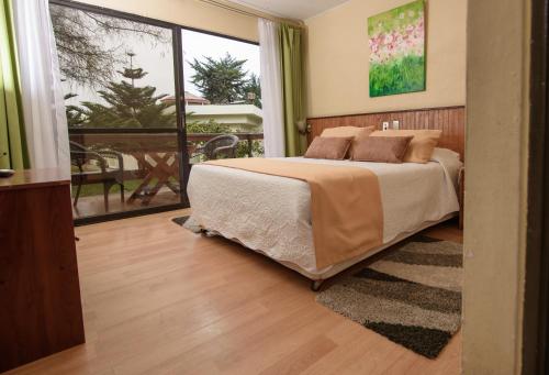 a bedroom with a bed and a balcony at Hotel del Valle Azapa in Arica