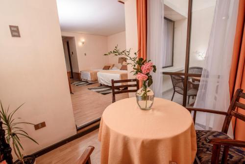 een vaas met bloemen op een tafel in een kamer bij Hotel del Valle Azapa in Arica