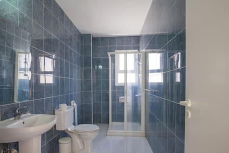 a bathroom with a toilet and a sink and a shower at Spacious 2 bedroom apartment in Peyia
