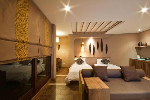 a hotel room with two beds and a couch at Montis Resort in Pai