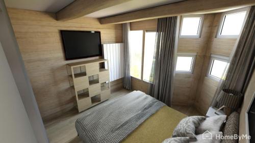 a bedroom with a flat screen tv on a wall at White Paradise in Val dʼIsère