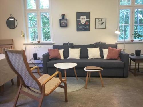 a living room with a couch and two tables at Rotzowlund BnB in Grenå