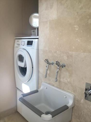 a bathroom with a washing machine and a washer at Rotzowlund BnB in Grenå