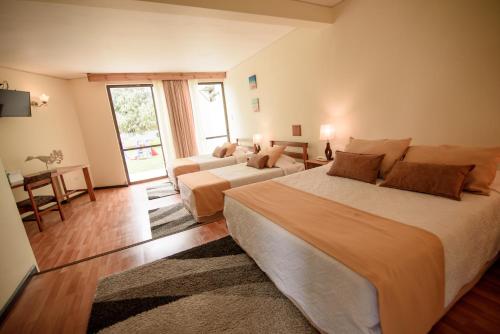 a large bedroom with a large bed and a couch at Hotel del Valle Azapa in Arica