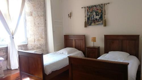 a bedroom with two beds and a window at Le Vieux Chateau in Airvault