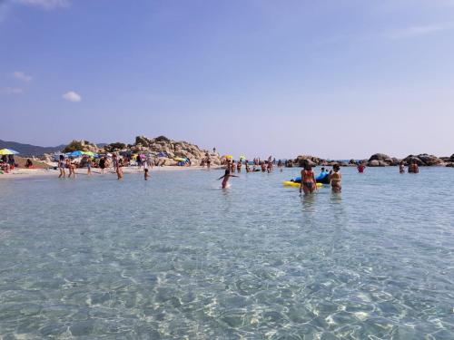 a group of people in the water at the beach at Sunny garden house in Villasimius