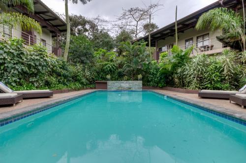 a swimming pool in front of a house at Forest Lodge in St Lucia