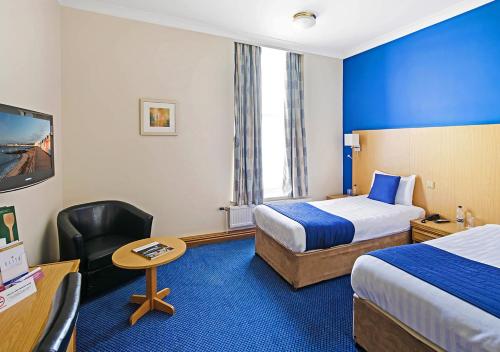 ハルにあるThe Royal Hotel Hullのベッド2台とデスクが備わるホテルルームです。