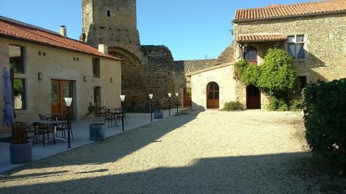 a courtyard of a castle with tables and a tower at Le Vieux Chateau in Airvault