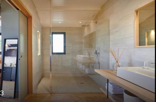 La salle de bains est pourvue d'une douche en verre et d'un lavabo. dans l'établissement Le Cabanon Bidart, à Bidart