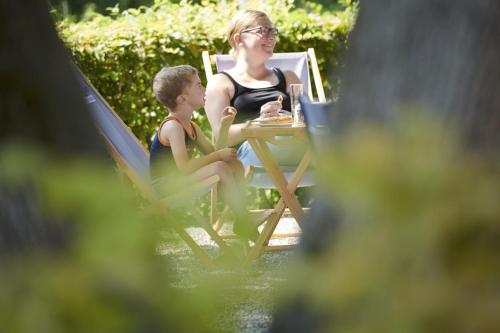 a woman and a boy sitting in chairs at a table at Radhotel am Gleis in Radolfzell am Bodensee