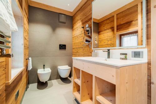 a bathroom with a sink and a toilet at Hotel Villa Alpina ***S in Cortina dʼAmpezzo