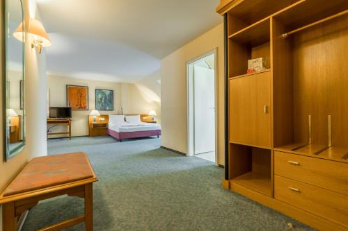 a hotel room with a bed and a bedroom at Galerie Hotel Leipziger Hof in Leipzig