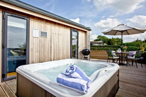 a bath tub with a teddy bear sitting in it at Perry Lodge, Strawberryfield Park - Hot Tub - Free Parking & WiFi in Cheddar