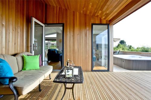 a living room with a couch and a tub at Perry Lodge, Strawberryfield Park - Hot Tub - Free Parking & WiFi in Cheddar