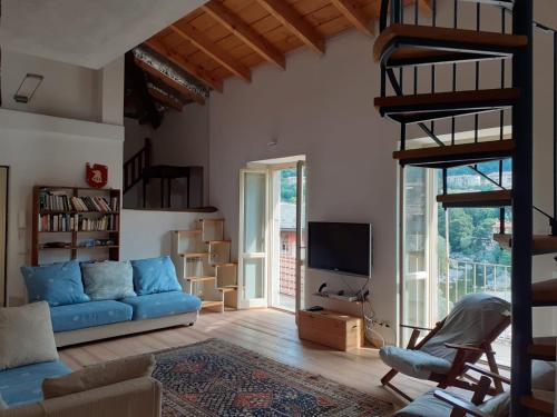 a living room with a blue couch and a tv at Attico sul Fiume in Varallo