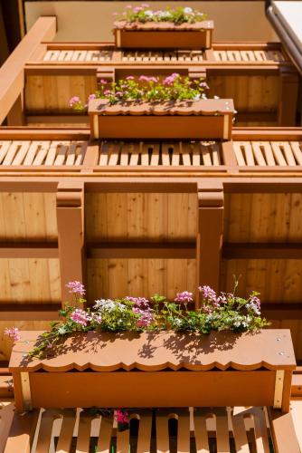 a building with flower boxes on the side of it at Hotel Villa Alpina ***S in Cortina dʼAmpezzo