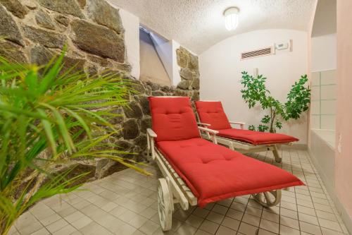 a waiting room with red chairs and plants at Galerie Hotel Leipziger Hof in Leipzig