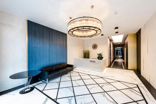 a lobby with a black couch and a table at Come&Stay apartments Wola in Warsaw