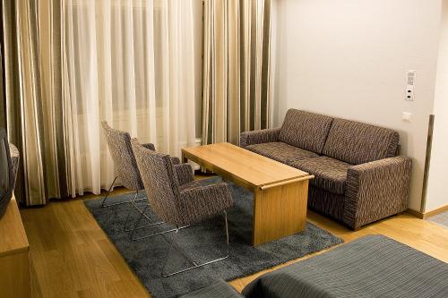 a living room with a couch and a table and chairs at Rokua Health & Spa in Rokua