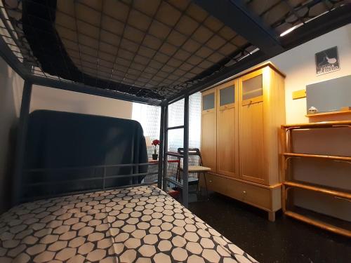 ジェノヴァにあるCentrale & Parkingのベッドと椅子が備わる小さな客室です。
