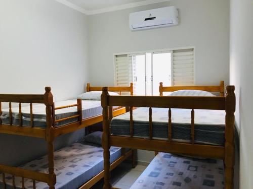 two bunk beds in a room with a window at Recanto da Família in Olímpia