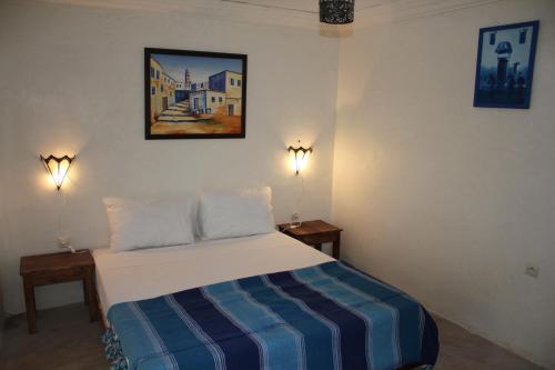 a bedroom with a bed and two lights on the wall at Kasbah de Ouirgane in Ouirgane