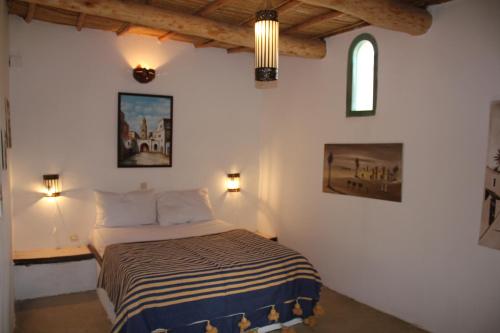 a bedroom with a bed and two pictures on the wall at Kasbah de Ouirgane in Ouirgane